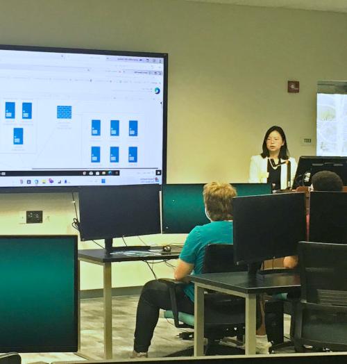 A teacher and pupils in a classroom learning about cyber security topics.