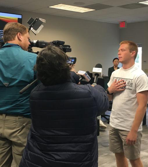 A news crew intervieweing a young student. 